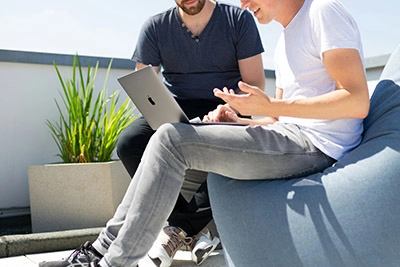 Two men comfortably seated on a colorful bean bag, engaged in conversation about their functional assessment